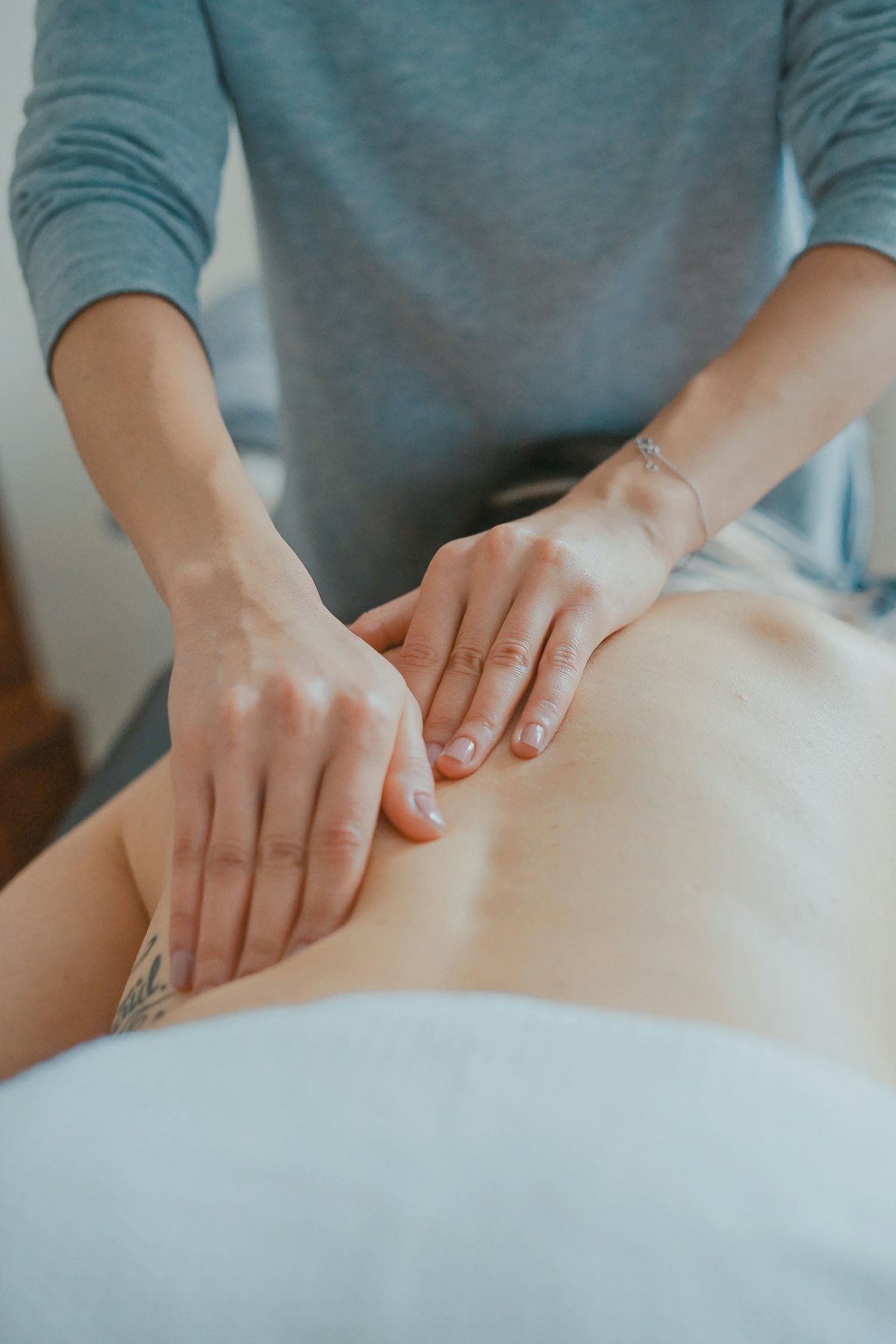 A massage therapist works on a client's back during an event treatment